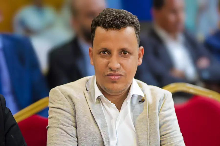 Portrait d’un invité, assis au premier rang d’une conférence.