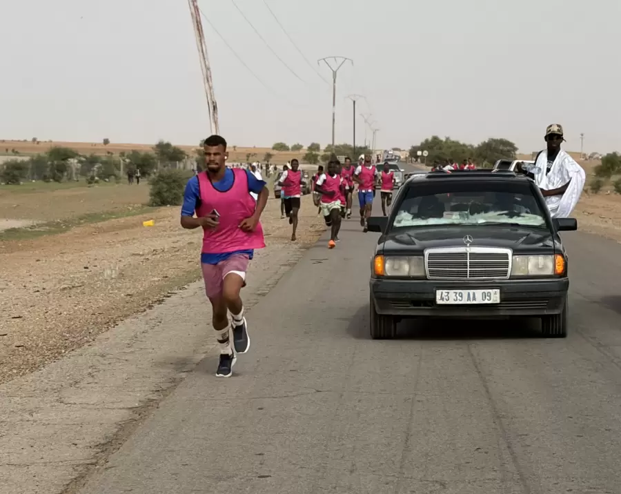 La voiture ouvreuse et les premiers coureurs, sur l’asphalte.