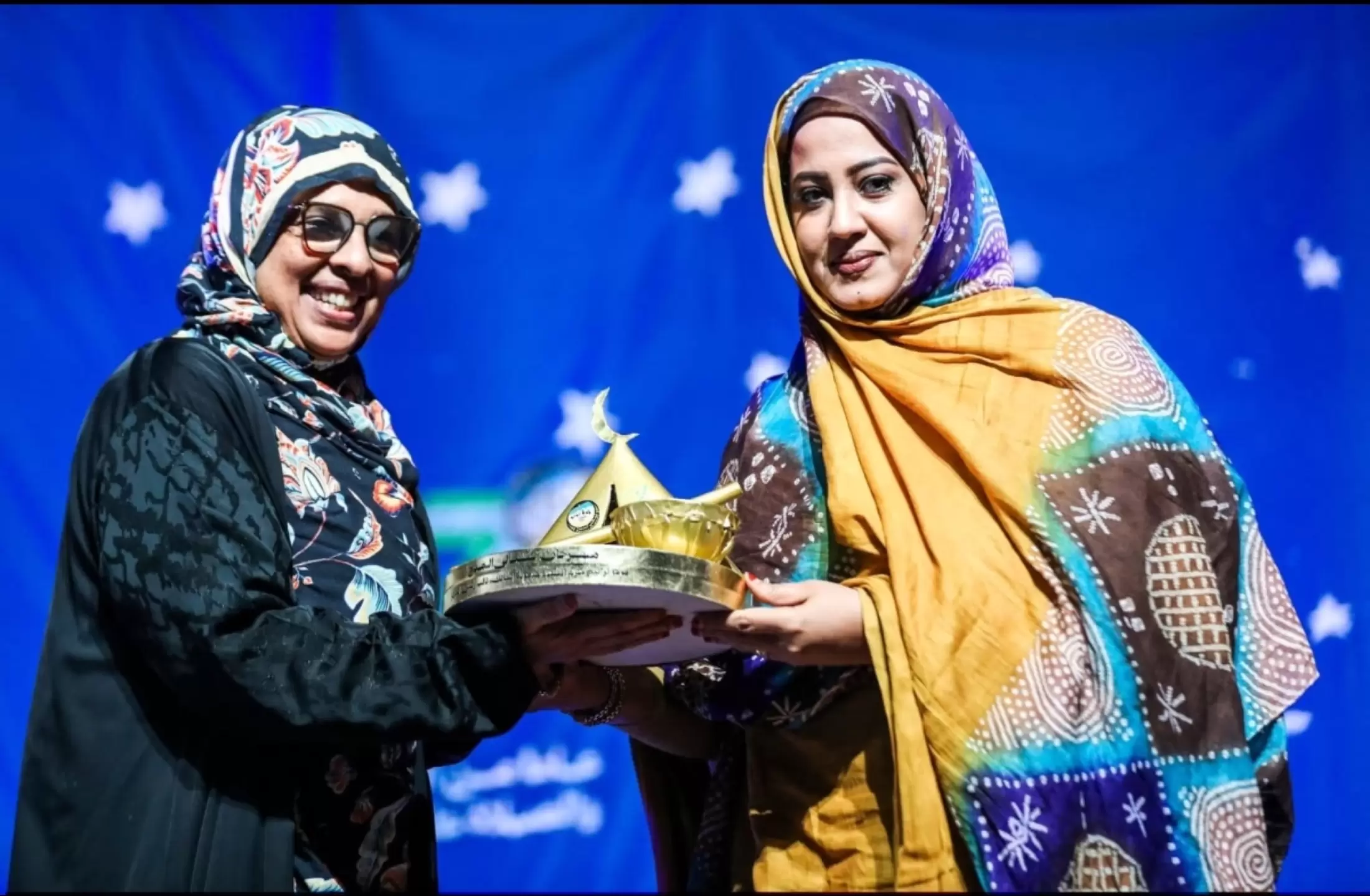 Deux femmes partagent le trophée lors de la cérémonie de clôture.