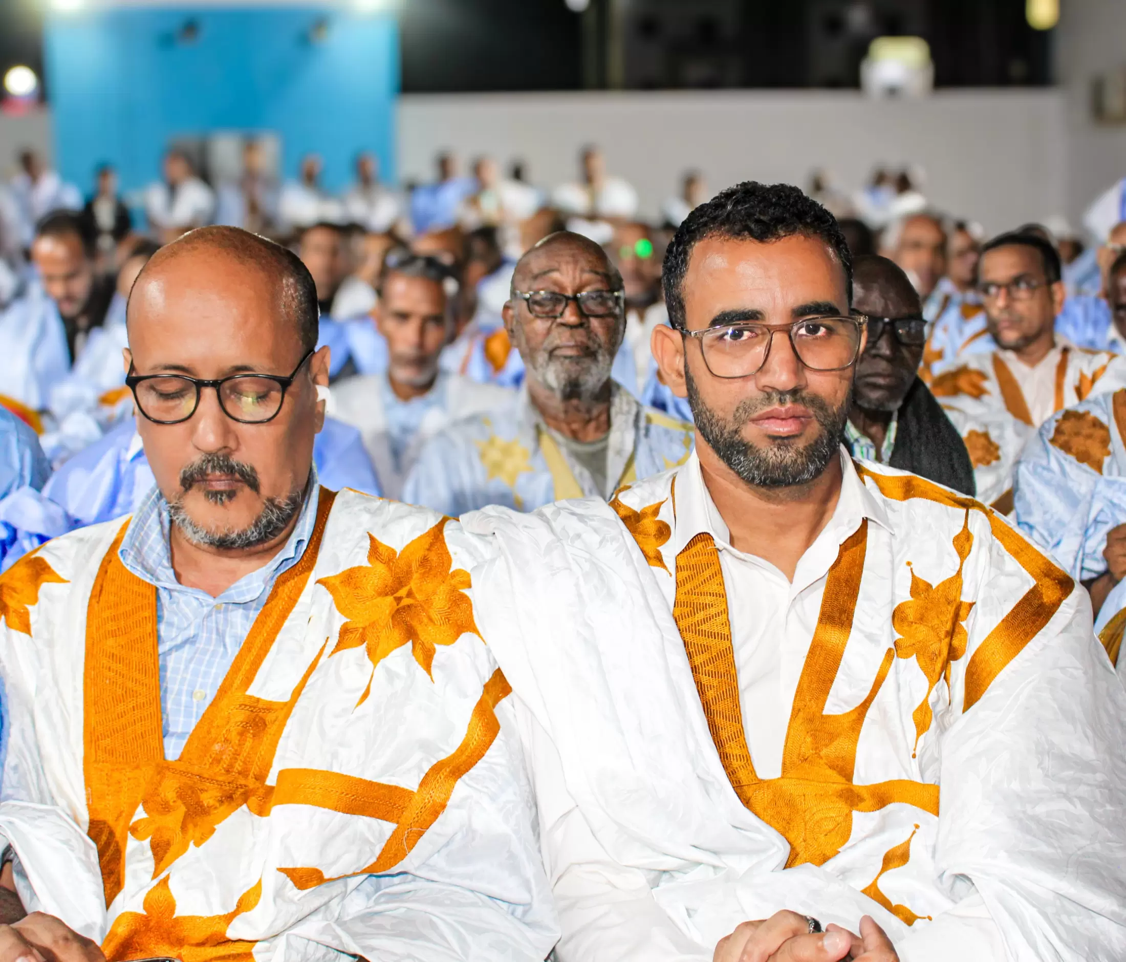 Deux participants côte à côte, dans la rumeur de la salle.