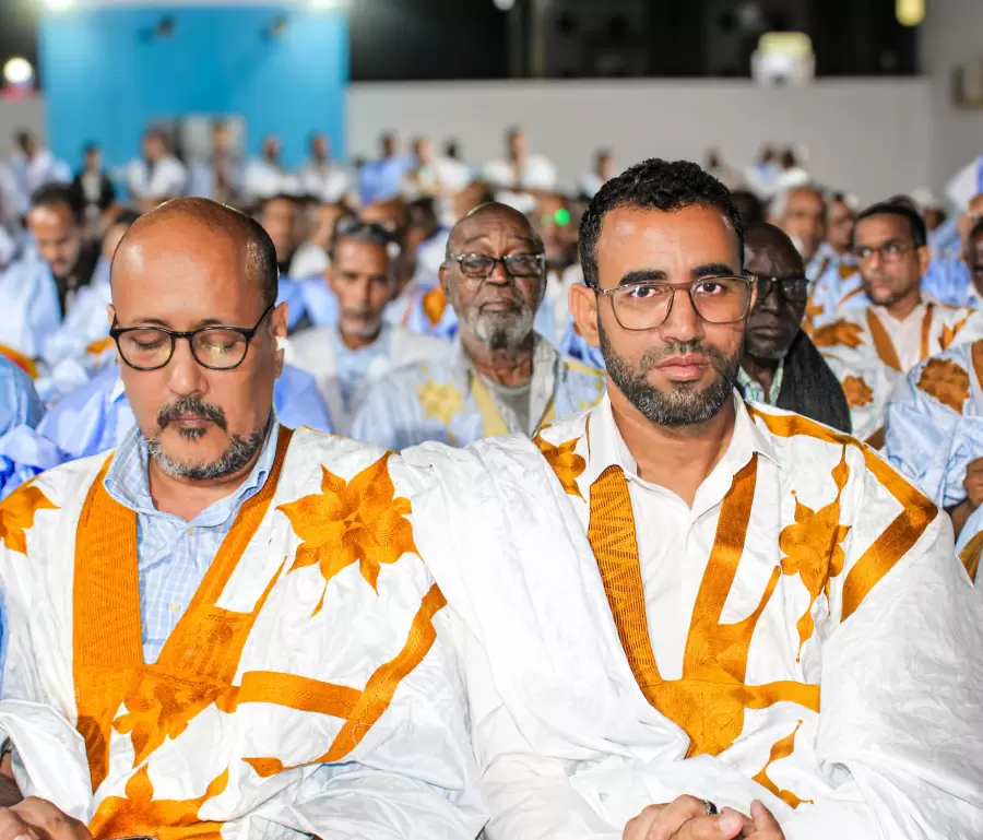 Deux participants côte à côte, dans la rumeur de la salle.