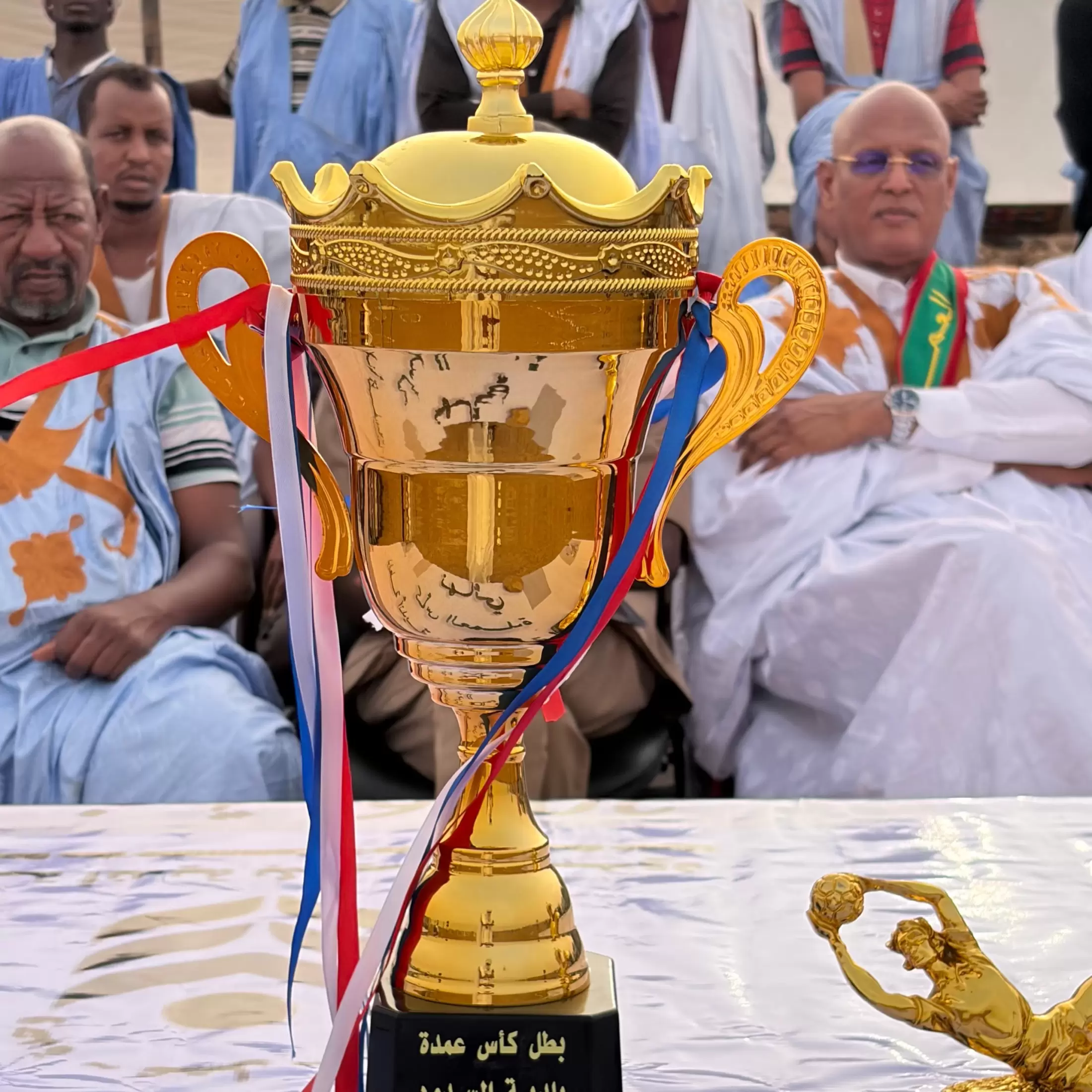 Gros plan sur le trophée doré, au premier rang de la cérémonie.