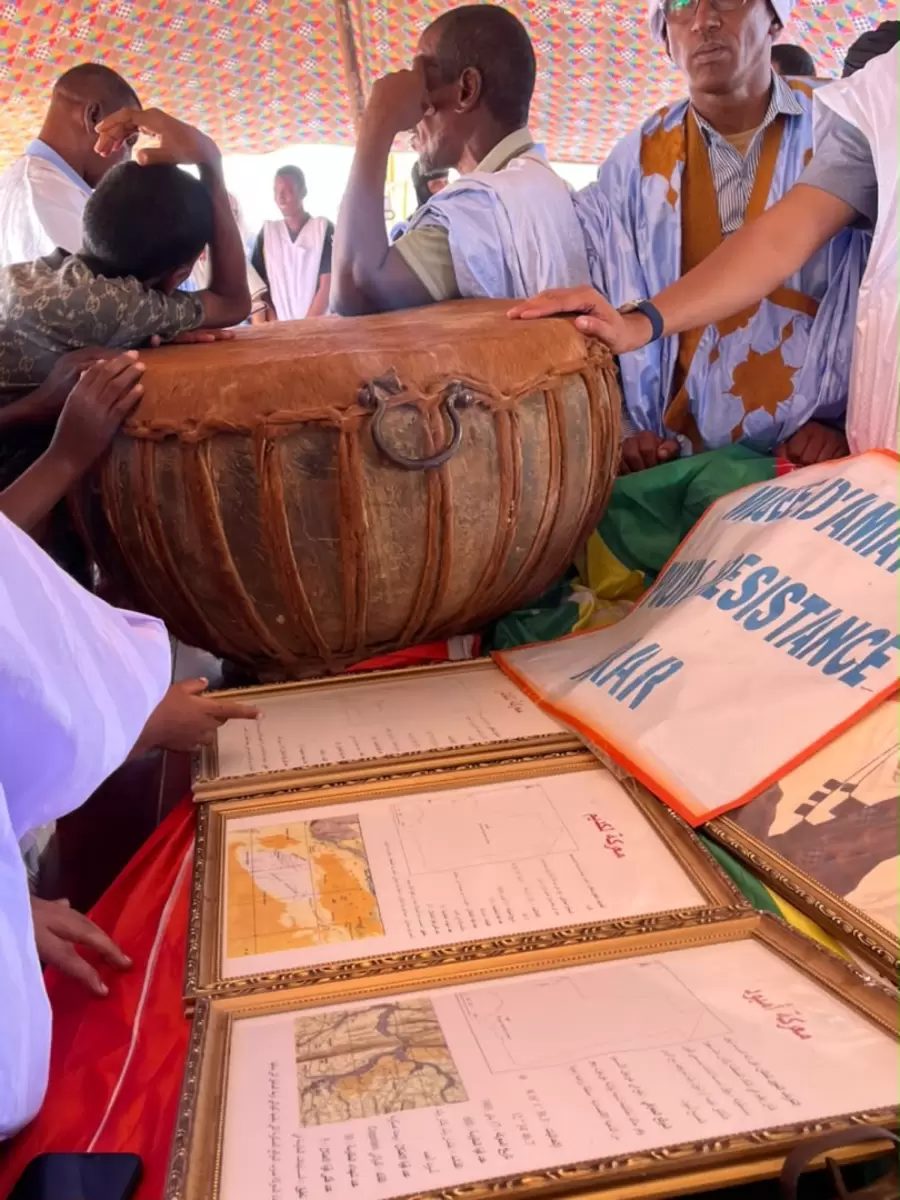 Un grand tambour de cuir voisine avec des documents encadrés.
