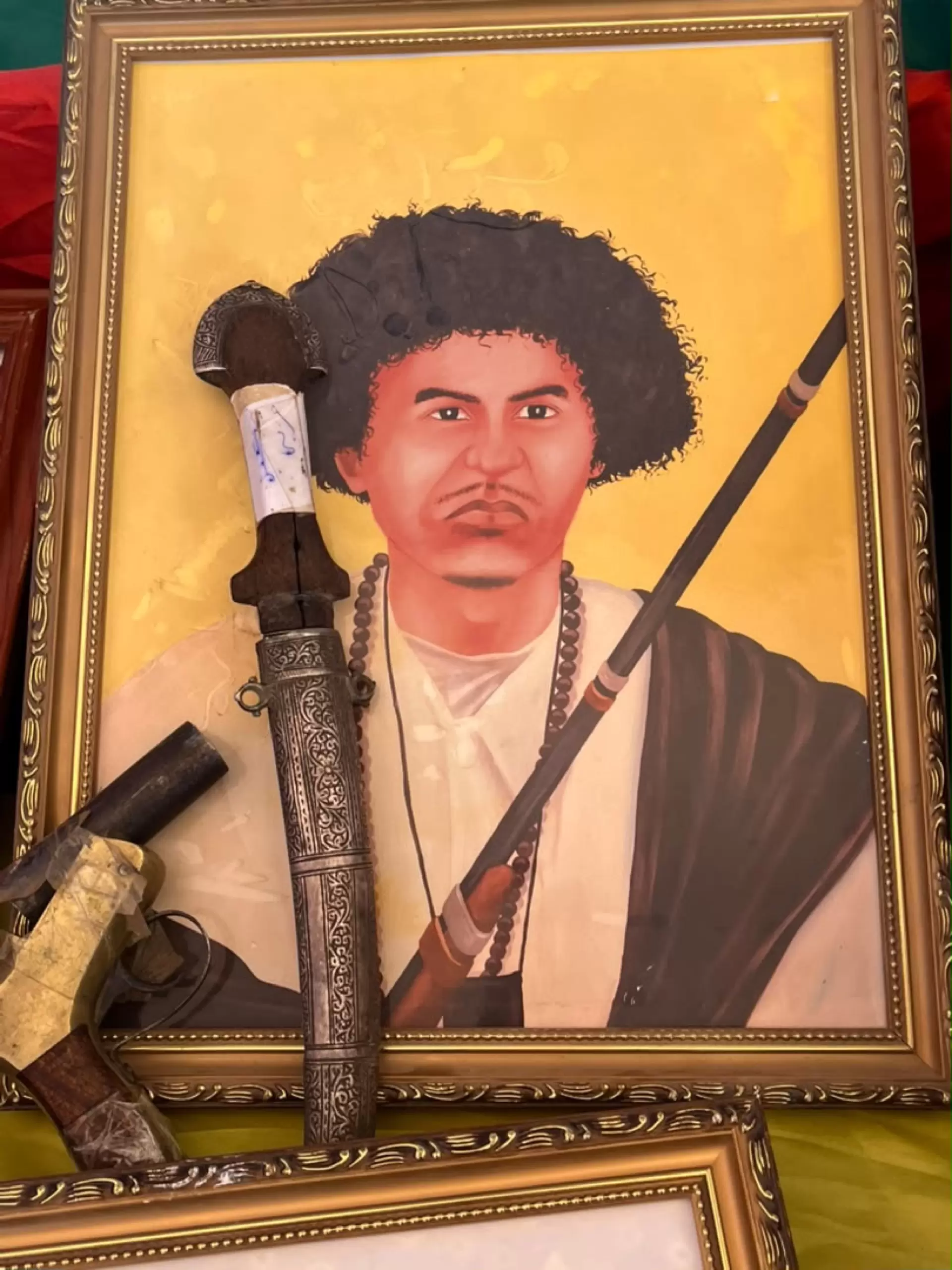 Un portrait peint, accompagné d’un poignard ancien, exposé au public.