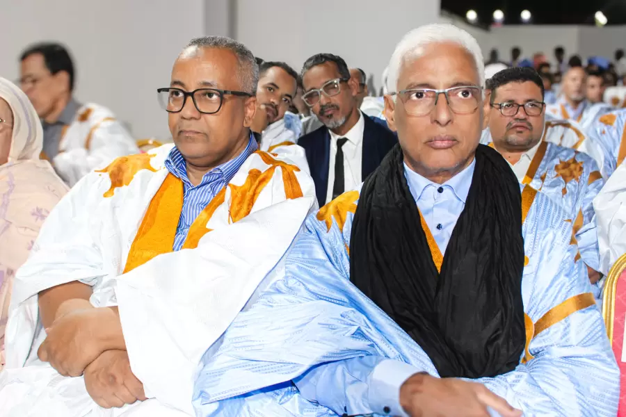 Des délégués en daraa blanche et orange, au premier rang du congrès.